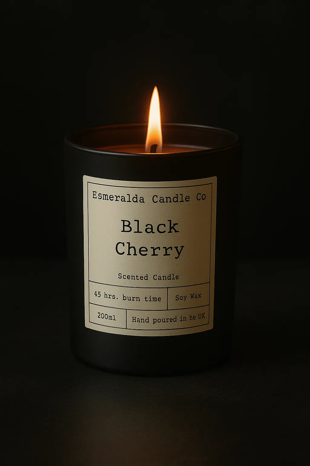 Esmeralda Candle Co Black Cherry scented candle in a black jar with warm flame, 45 hours burn time, 200ml hand-poured soy wax, displayed on a marble surface.