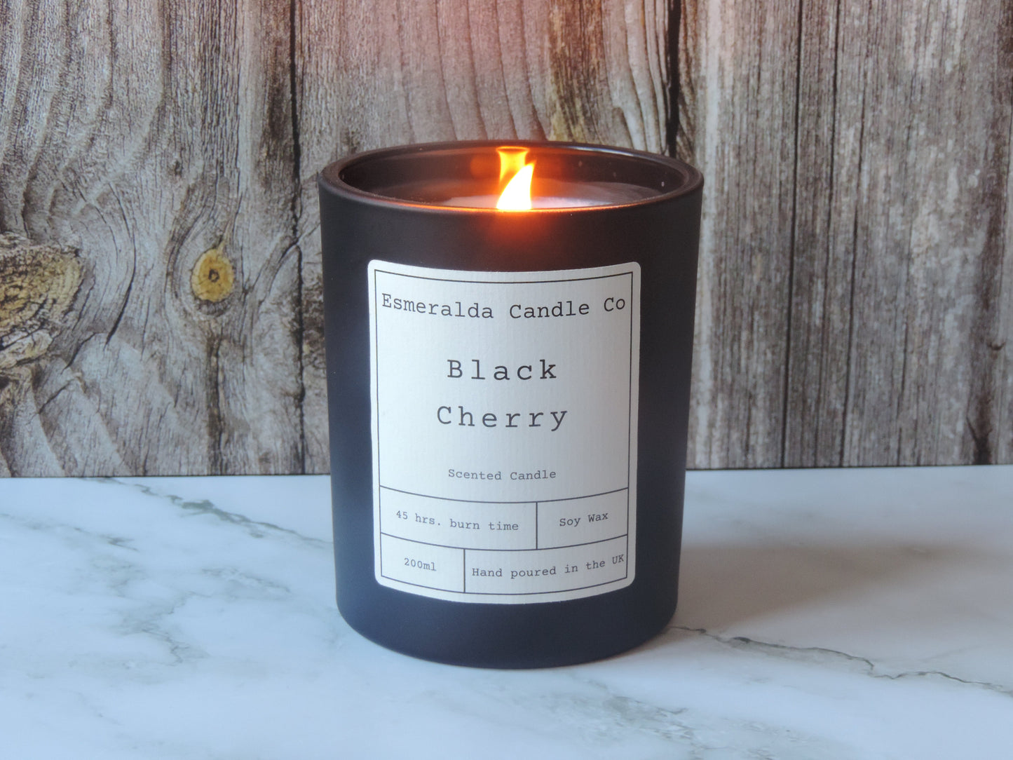 black cherry scented candle in a matt black glass jar with a white sticker
