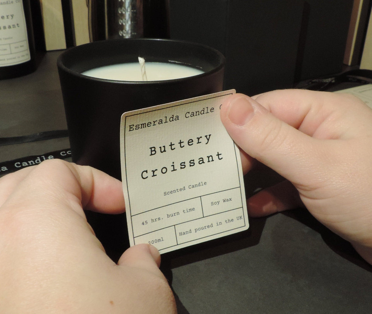 placing a sticker on a black glass candle