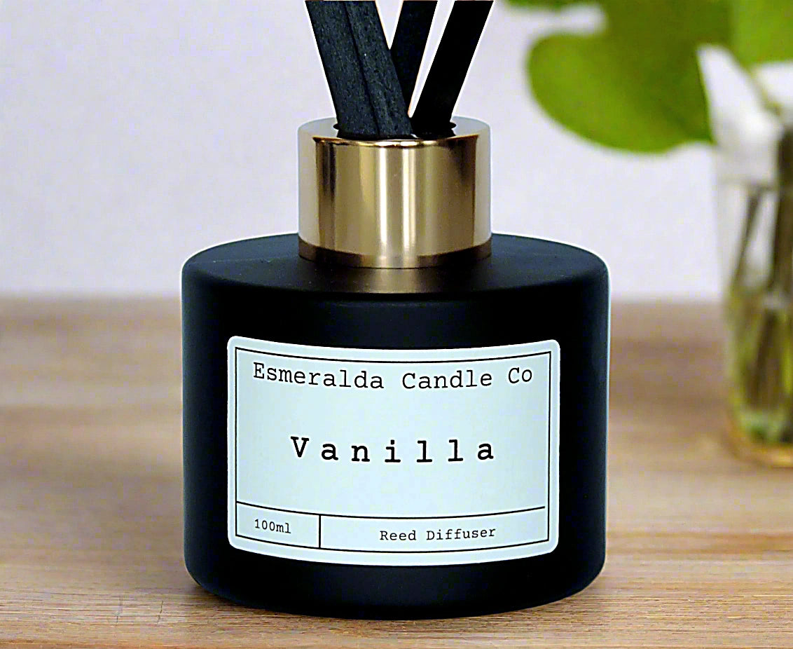 Vanilla reed diffuser by Esmeralda Candle Co, 100ml matte black bottle with gold collar and black reeds, warm and comforting home fragrance.