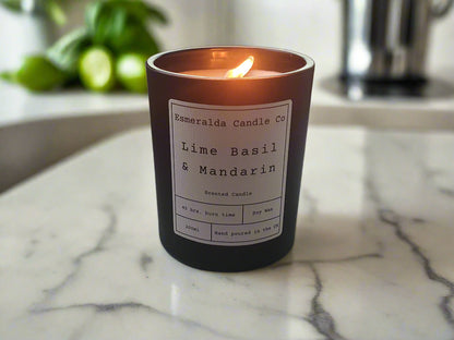 Candle with a label on a desk next to a computer monitor