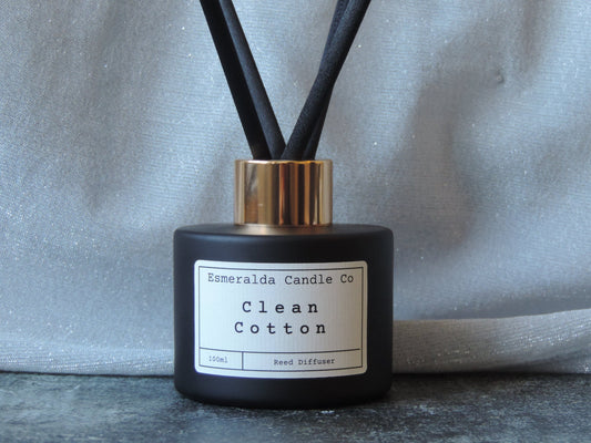 reed diffuser with fresh clean cotton scent in matt black 100ml glass bottle with a gold lid and 4 extra thick reeds