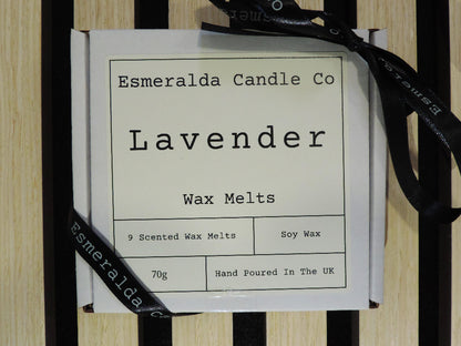 A white box labelled 'Esmeralda Candle Co – Lavender Wax Melts' tied with a black ribbon, containing 9 soy wax melts, placed on a striped wooden background.