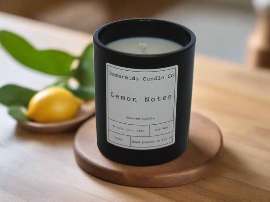 Esmeralda Candle Co Lemon Notes scented soy wax candle in black jar, 45-hour burn time, hand poured in the UK, styled with fresh lemon and leaves on wooden tray.