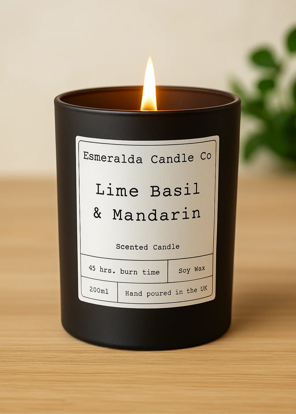 Black candle with a label reading 'Esmeralda Candle Co Lime Basil & Mandarin' on a wooden surface.