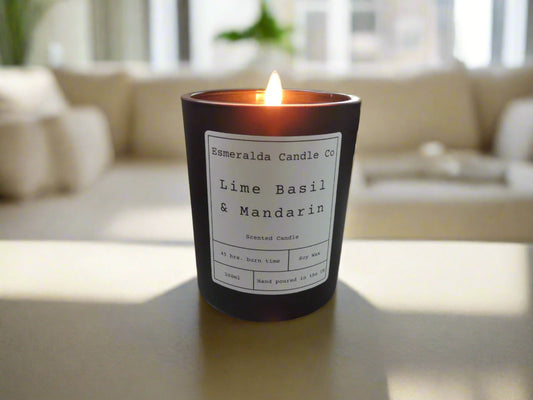Lit Lime Basil & Mandarin scented soy wax candle by Esmeralda Candle Co, hand poured in the UK, placed on a coffee table in a bright, modern living room for a fresh home ambiance.