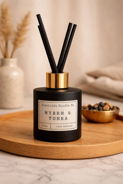 Myrrh & Tonka reed diffuser by Esmeralda Candle Co in matte black glass with gold collar, styled in luxury neutral home interior