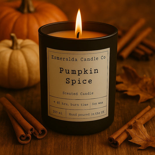 Pumpkin spice scented candle with pumpkins and cinnamon sticks on a wooden surface made by Esmeralda Candle co