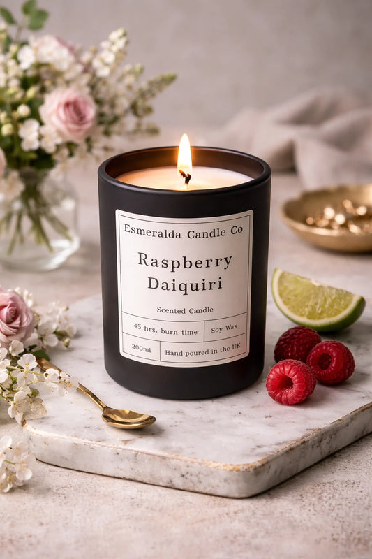 Luxury Raspberry Daiquiri scented candle in a matte black glass jar by Esmeralda Candle Co, hand-poured soy wax candle with soft neutral background.