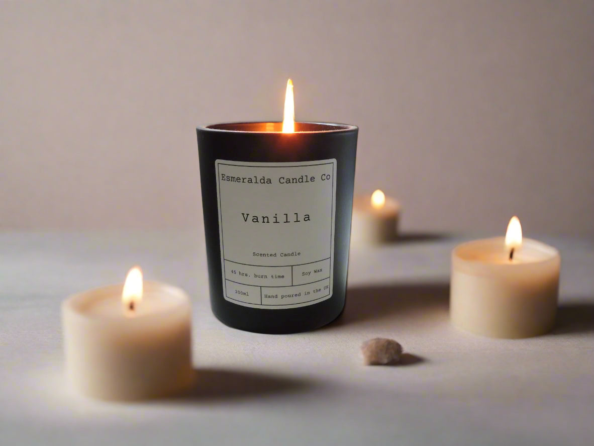 Vanilla scented soy wax candle by Esmeralda Candle Co, hand poured in the UK, lit and surrounded by tealight candles for a relaxing and aromatic atmosphere