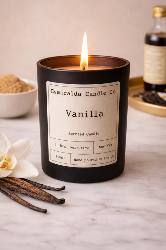 Vanilla scented candle with vanilla beans and flowers on a marble surface